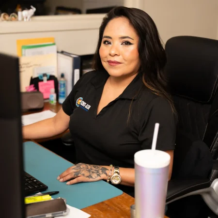 CMI office worker smiling at her desk